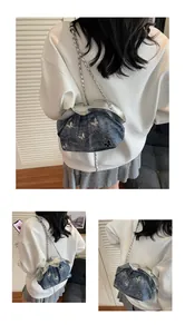 Detail of blue denim bucket bag with silver butterfly accents and pleated cloud texture