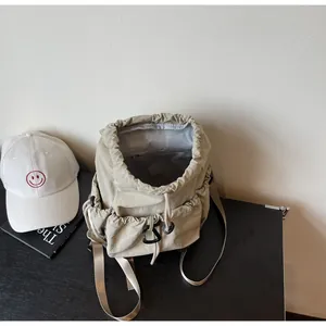 Minimalist beige nylon drawstring backpack with mountaineering buckle and multi-pocket design