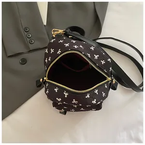 Minimalist black backpack with white bow prints and golden metal zippers for daily commute