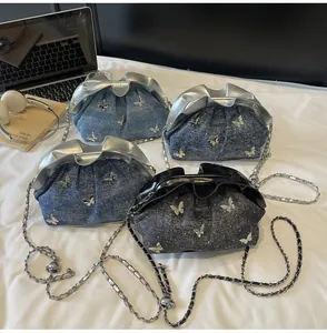 Close-up of stylish butterfly denim bucket bags in various blue tones with chain straps