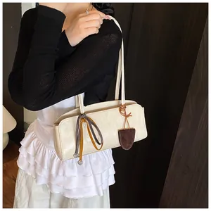 Détail du sac à bandoulière rétro blanc cassé avec foulard et breloque en mode lifestyle