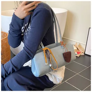 Vue détaillée du sac polochon vintage avec pendentif cœur et texture en cuir souple mat