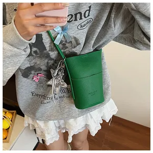 Detail of emerald green lychee leather mini crossbody bag with star pendant
