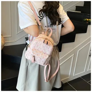 Detail of pink embossed backpack with gold hardware and stylish textured fabric