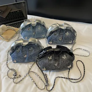 Chic pleated bucket bags with butterfly charms and metal chain straps in denim and black