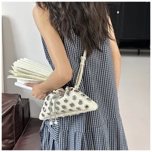 Detail of off-white triangle bucket bag with silver metal eyelets and pearl drawstring