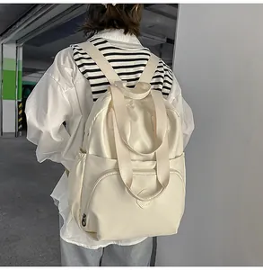 Detail of cream-colored waterproof nylon backpack with multi-compartments and top handle