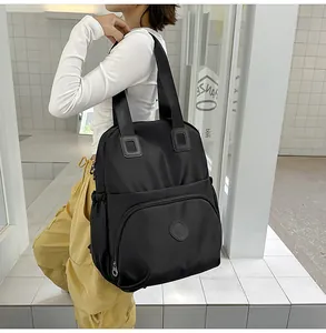 Detailed back view of a black multi-pocket waterproof nylon backpack on a model