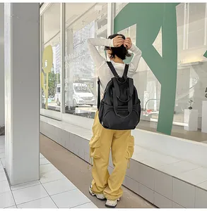 Waterproof black round backpack for women shown with casual outfit in a modern city setting
