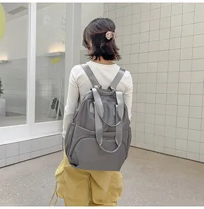 Rear view of a grey nylon backpack featuring multiple pockets and waterproof fabric
