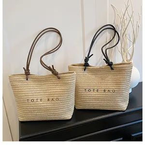 Detail view of woven tote bags with TOTE BAG embroidery and cord knotted handles