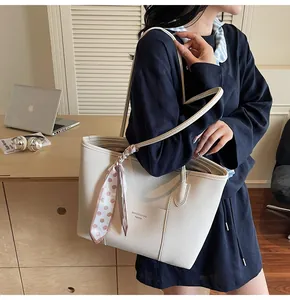 Detail of cream white pebbled leather tote bag with stylish pink polka dot scarf handle