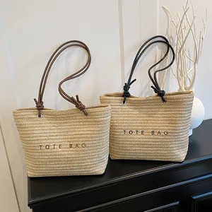 Straw tote bag with TOTE BAG embroidery and leather shoulder straps for beach vacations