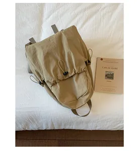 Detail of khaki nylon backpack with drawstring closure and soft pleated texture