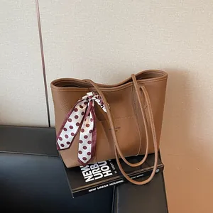 Brown litchi grain leather tote bag with elegant polka dot scarf for daily commute