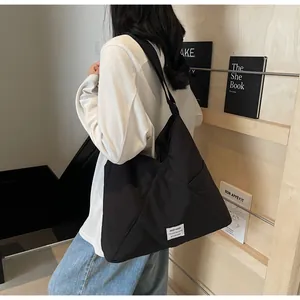 Detail view of a large black canvas tote bag showing the textured fabric and logo label