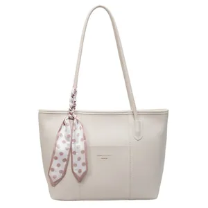 Minimalist beige tote bag in lychee texture leather with decorative polka dot silk scarf