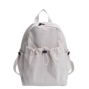 Minimalist beige nylon backpack with drawstring front pocket and dual zipper closure