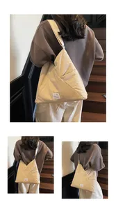 Detailed close-up of beige triangle tote bag with unique texture and side pocket