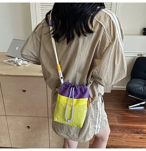 Detail of trendy bucket bag showing purple and yellow nylon mesh and drawstring rope strap