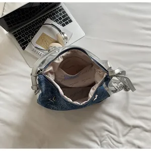 Détail du sac cabas en denim bleu avec ornement papillon, doublure et poche zippée