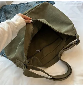 Detalle del interior espacioso con múltiples compartimentos con cremallera del bolso verde oliva