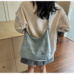 Grand sac cabas pailleté bleu clair avec papillons argentés porté à l'épaule