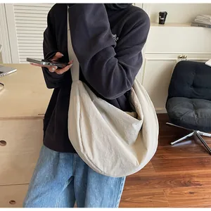 Side view of cream white nylon hobo bag featuring soft pleats and large capacity