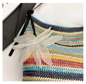 Close-up of a floral charm with translucent petals on a rainbow striped woven bag