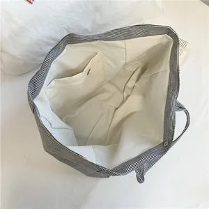 Striped canvas tote bag with black and white patterns and magnetic buckle closure