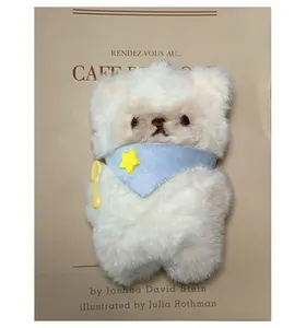 Close-up of fluffy white bear plush charm with blue star scarf and yellow spoon accessory