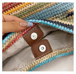 Detail of the high-quality double magnetic buckles on a rainbow straw woven bucket bag