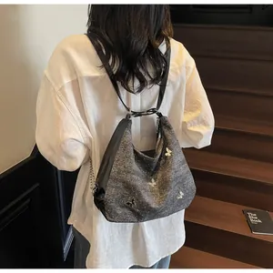 Détail du cabas gris scintillant avec motifs papillons et anses en cuir noir