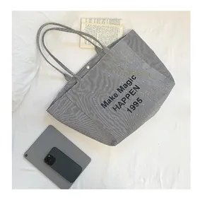Detail of striped canvas tote bag with magnetic clasp closure and interior view