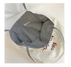 Detail of canvas tote bag showing striped lining and interior label craftsmanship