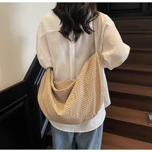 Rear view of khaki checkered shoulder bag on model against wooden stairs background