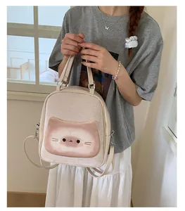 Detailed view of cream cat print tote bag worn by model in casual lifestyle setting