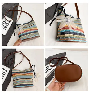 Detail view of colorful rainbow striped straw bucket bag with floral charm and leather strap