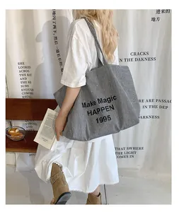 Detailed view of striped canvas tote bag featuring Make Magic Happen printed slogan