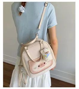 Rear view of a model wearing the cream cat-themed backpack with a plush bear charm