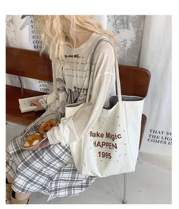 Detail of white canvas tote bag with red text print on model in casual lifestyle setting