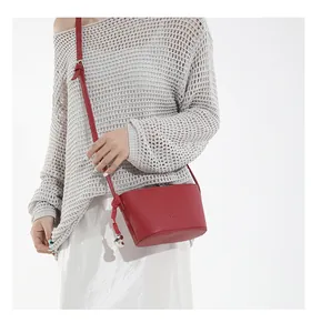Detail of red lychee pattern bucket bag with fashion embossing and silver pendant