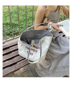 Detail of the canvas tote bag showing the striped interior and 'YOU'RE SO CUTE' woven label