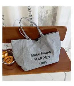 Close-up of a striped canvas tote bag with Make Magic Happen graphic on a wooden bench