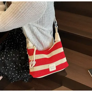 Détail du sac en tricot à rayures rouges et blanches avec étiquette et perles