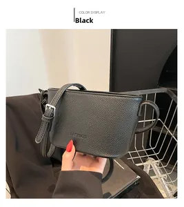 Detail of black lychee grain leather bucket bag featuring silver buckle and fashion embossing