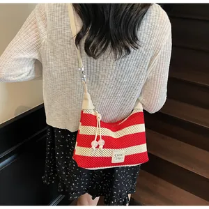 Détail du sac en tricot à rayures rouges et blanches avec perles et étiquette chic
