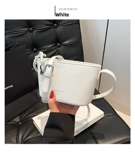 Detailed close-up of white lychee pattern bucket bag with silver hardware and FASHION logo