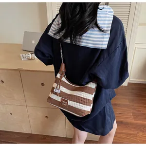 Sac à bandoulière en maille rayée avec bandoulière en cuir marron en situation