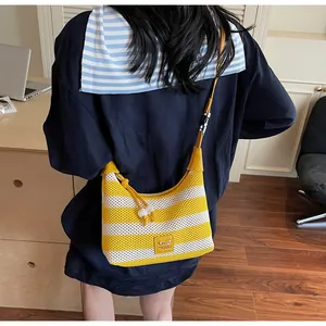 Détail du sac à bandoulière en tricot rayé jaune avec perles et étiquette en cuir